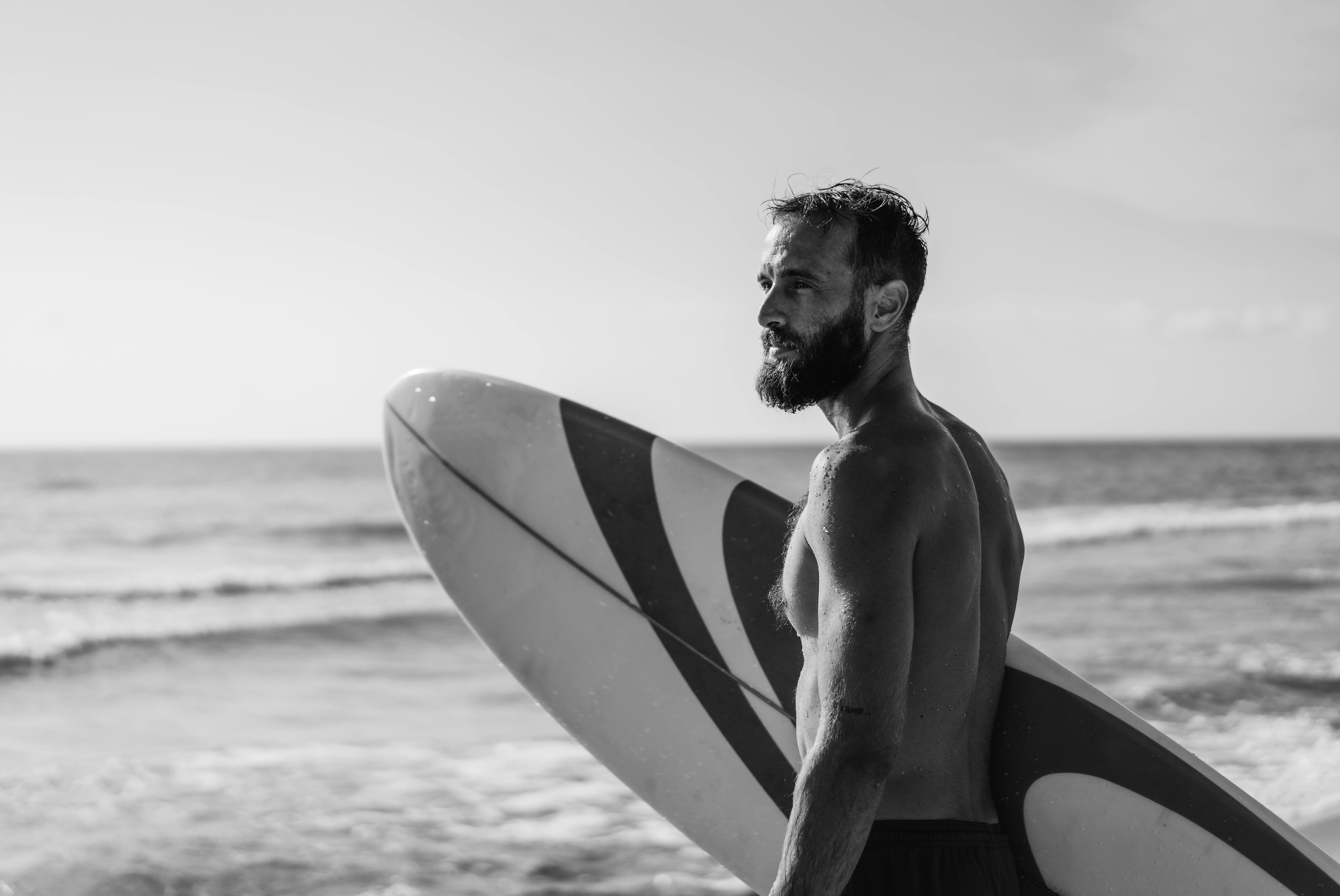 Surfer walking along the beach